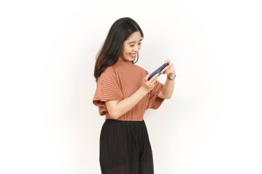 Beyaz arka planda izole edilmiş güzel Asyalı kadının akıllı telefonunda oyunlar oynuyorum.