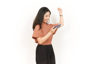 Beyaz arka planda izole edilmiş güzel Asyalı kadının akıllı telefonunda oyunlar oynuyorum.
