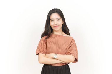 Çapraz gülümseyen kollar ve beyaz arka planda izole edilmiş güzel Asyalı kadının kamerasına bakın.