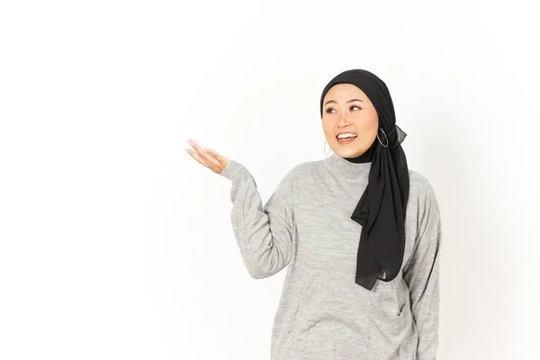 白い背景に孤立したヒジャブを身に着けている美しいアジアの女性の手のひらに製品を発表 — ストック写真
