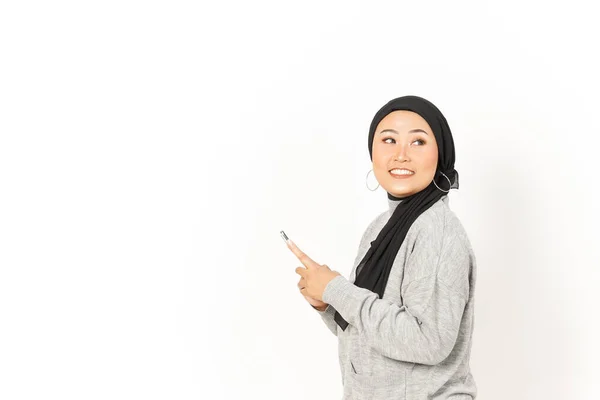 笑着使用智能手机的美丽的亚洲女人带着Hijab与白色背景隔离 — 图库照片