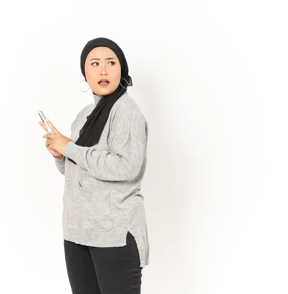 笑着使用智能手机的美丽的亚洲女人带着Hijab与白色背景隔离 — 图库照片