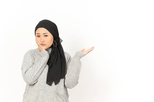 白い背景に孤立したヒジャーブを身に着けている美しいアジアの女性の手のひらに心配そうな顔と製品を示す — ストック写真