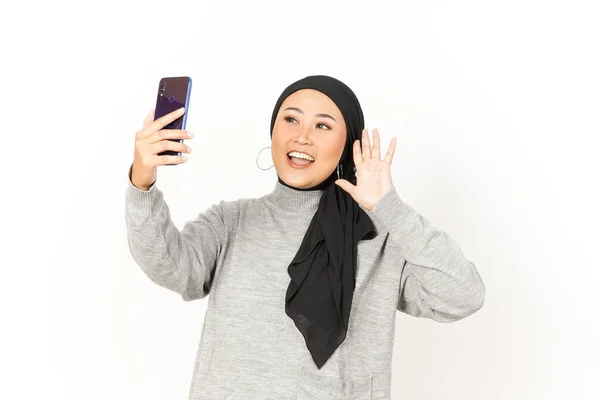 白い背景にHijabを身に着けている美しいアジアの女性のスマートフォンを使用してセルフィーを取る — ストック写真