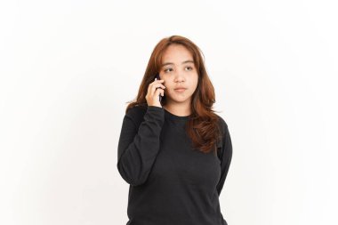 Beyaz arka planda izole edilmiş siyah gömlekli güzel bir Asyalı kadının akıllı telefonundan konuşuyorum.