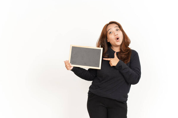 Показывая, представляя и держа пустую доску красивой азиатки в черной рубашке