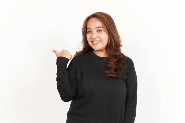 白に隔離された黒いシャツを着て美しいアジアの女性の親指を使用して製品を指す — ストック写真