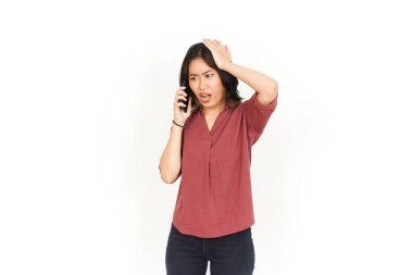 Beyaz arka planda izole edilmiş Asyalı güzel bir kadının kızgın suratını kullanarak bir telefon görüşmesi yap.