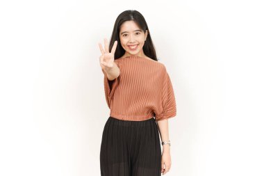 Beyaz arka planda izole edilmiş güzel bir Asyalı kadının üç parmağını gösteriyor.
