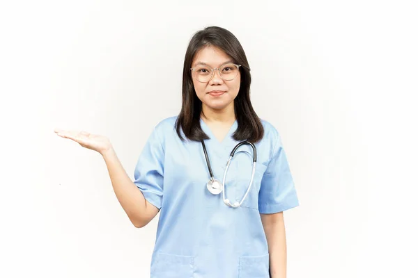 白い背景に隔離されたアジアの若い医師のオープンパームに製品を表示し 提示する — ストック写真