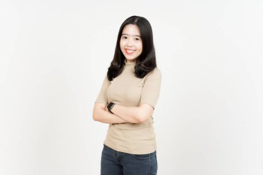 Katlanan kollar gülümse ve beyaz arka planda izole edilmiş güzel Asyalı kadının kamerasına bak.