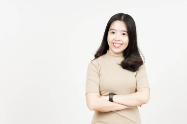 Katlanan kollar gülümse ve beyaz arka planda izole edilmiş güzel Asyalı kadının kamerasına bak.