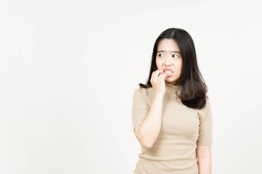 Beyaz arka planda yalnız bırakılmış güzel Asyalı kadının tırnak yemesi ve korkması.