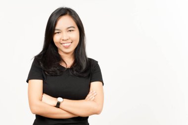 Beyaz arka planda yalnız bırakılmış güzel Asyalı kadının kollarını kavuşturup gülümsüyor.