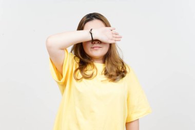 Beyaz tenli sarı tişört giyen güzel Asyalı kadının kollarını kullanarak gözleri kapatıyor.