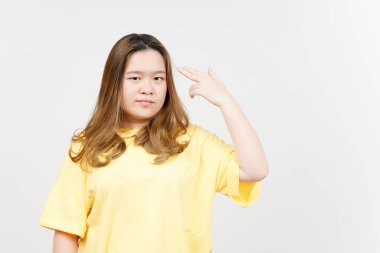 Beyaz arka planda izole edilmiş sarı tişört giyen güzel Asyalı kadının kafasında silah parmağı var.