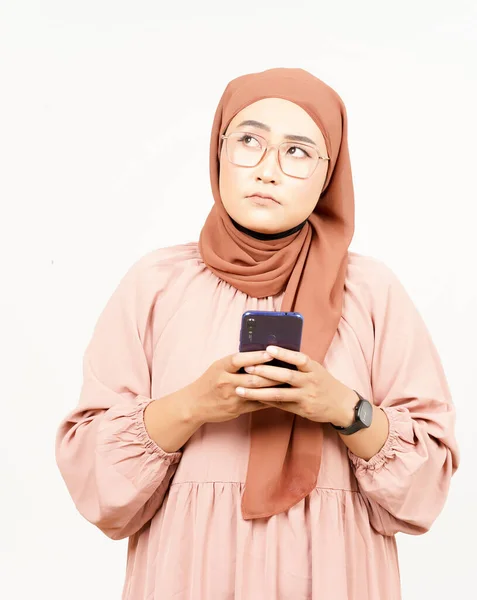 白い背景に隔離されたヒジャブを身に着けている美しいアジアの女性のスマートフォンを保持または使用 — ストック写真
