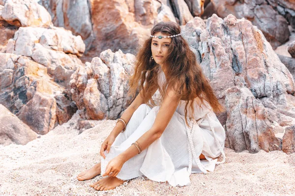 ビーチで砂の上に座って美しい若いスタイリッシュな女性 — ストック写真