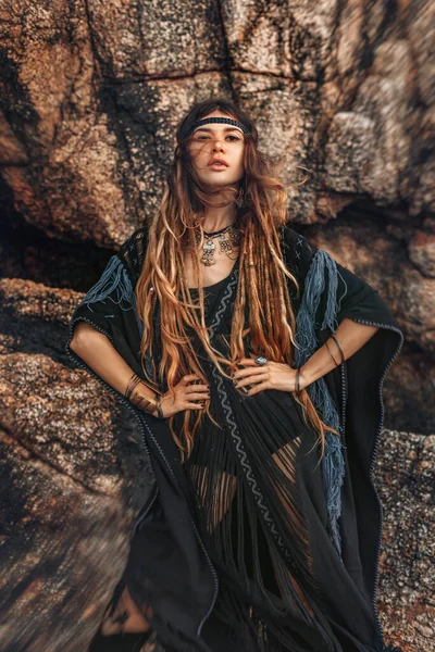 Gün batımında poz veren güzel, genç bir kadın.