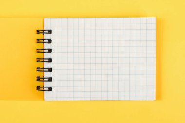 Sarı arka planda boş bir sayfası olan sarı not defteri. Metin ya da tasarım için boş. maketleme.