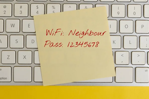 The concept of poor home wifi network security. Weak password. Access information on a leaflet lying on the keyboard. View from above.