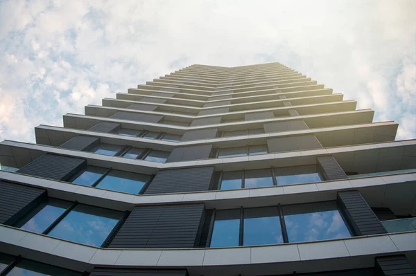 Tall modern high tech style building agains the sky with clouds. Copy space.