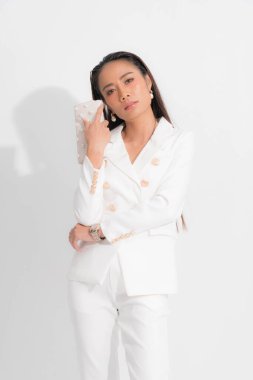 İş kadını için moda tarzı katalog kıyafetleri. Siyah uzun saçlar. Makyaj. Beyaz takım elbise..