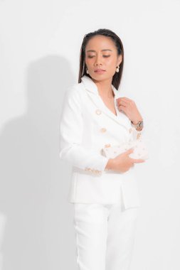 İş kadını için moda tarzı katalog kıyafetleri. Siyah uzun saçlar. Makyaj. Beyaz takım elbise..