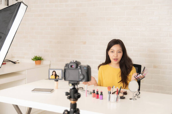 Красивая женщина-блоггер показывает, как сделать и использовать косметику. Перед камерой записывать видео в режиме реального времени дома.