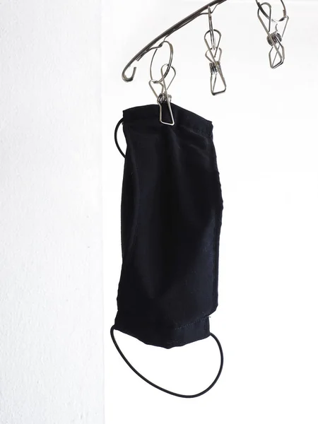 Hanging Dried Black Fabric Protective Face Mask Clip White Cement — стоковое фото