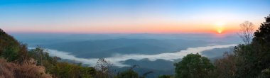 wide horizontal panorama landscape view from peak of Doi Samer Dao in Nan, Thailand with sea mist and sunrise sky. Beautiful moment the miracle of nature. Misty valley. Foggy mountains.