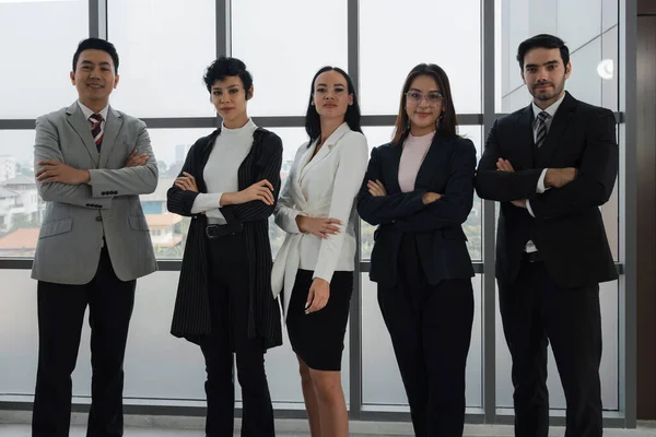 portrait group of mixed ethnic and aged professional businesspeople standing in the office
