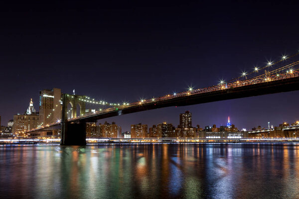 Night view of the Brooklyn Bridge from Manhattan in the background.