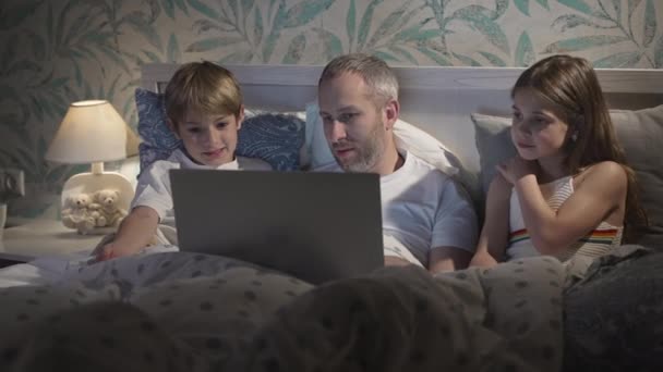 Familia usando portátil en la cama. — Vídeos de Stock