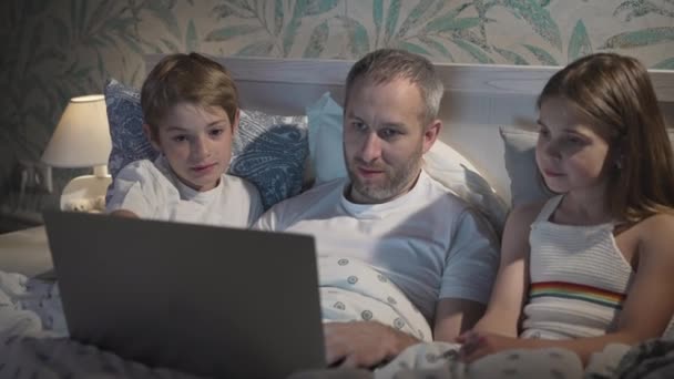 Familjen Tittar Film Med Digital Laptop Sängen Far Med Barn — Stockvideo