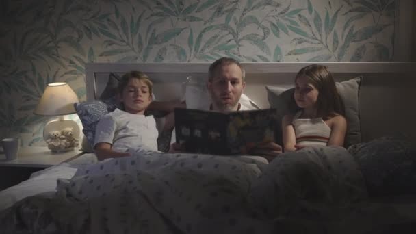 Famille utilisant un ordinateur portable au lit. — Video