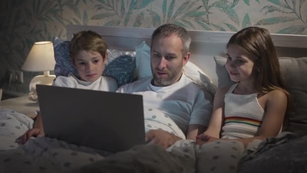 Familj som använder laptop i sängen. — Stockvideo