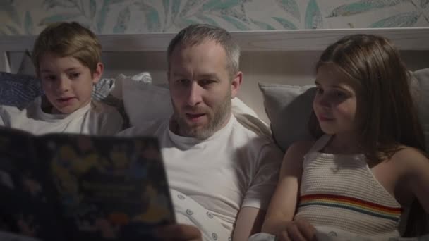 Семья с помощью ноутбука в постели. — стоковое видео