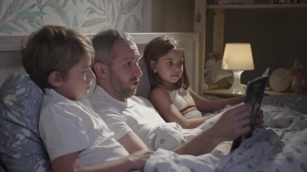 Yatakta dizüstü bilgisayar kullanan aile. — Stok video