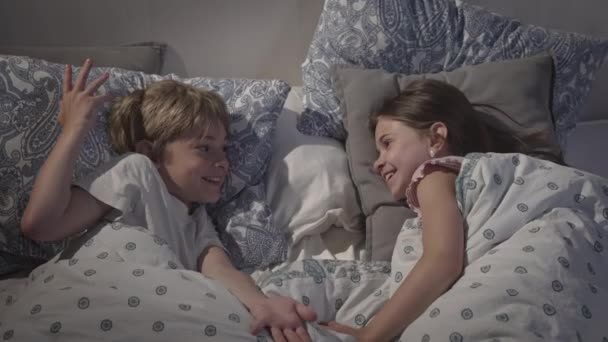 Gyerekek beszélgetnek az ágyban.. — Stock videók