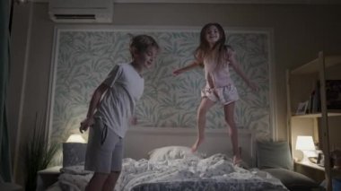 Güzel gülümseyen çocuklar yatak odasında eğleniyorlar..