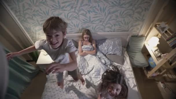 Roztomilé usmívající se děti baví v ložnici. — Stock video