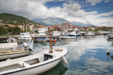 Limandaki tekne ve tekneler, kentin ve dağların zeminine karşı, Tivat, Karadağ.