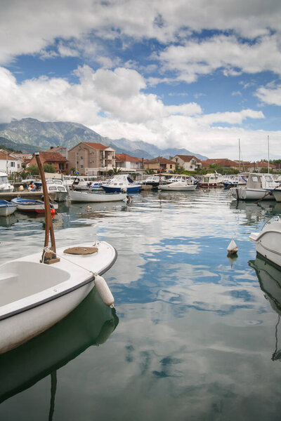 Boats and boats in the port against the backdrop of the city and mountains, Tivat, Montenegro.