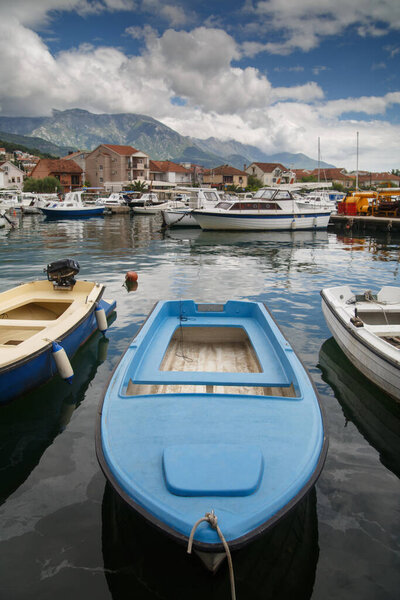 Boats and boats in the port against the backdrop of the city and mountains, Tivat, Montenegro.