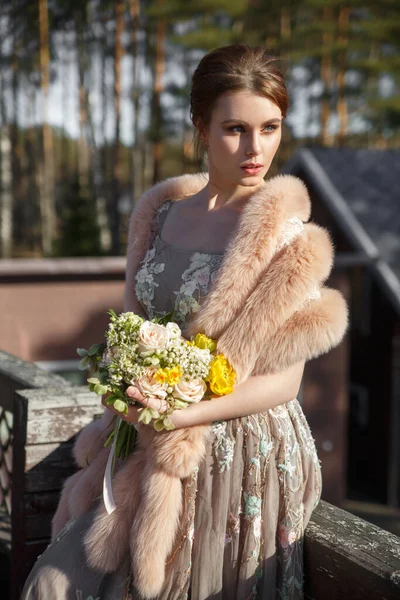 穿着时髦衣服 手里拿着一束花 背景简朴的优雅姑娘 — 图库照片