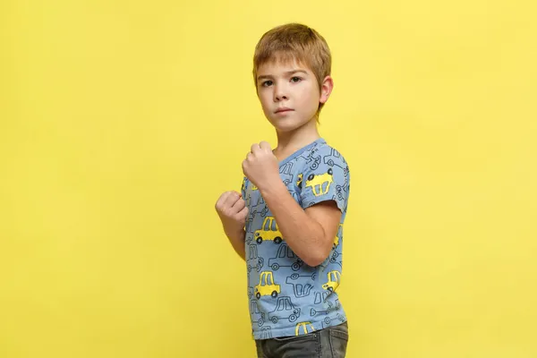 Liten Känslomässig Pojke Casual Kläder Kämpande Hållning Isolerad Gul Bakgrund — Stockfoto