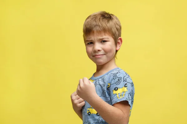 Malý Emocionální Chlapec Ležérní Oblečení Bojovém Postoji Izolované Žlutém Pozadí — Stock fotografie