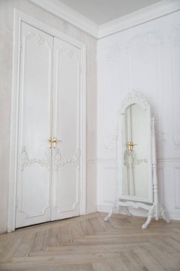 Şık bir salonda askıda duran çerçeveli bir ayna ile iç mekan..