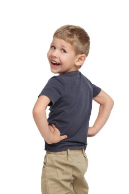 Gündelik giysiler içinde küçük sevimli bir çocuk beyaz arka planda izole bir şekilde dönüyor..